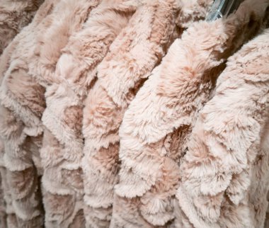 Kışın giysi askılığında satılmak üzere yün ve sahte kürklü bir ceket.