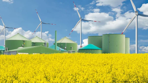 Biogasanlage Steht Hinter Einem Rapsfeld Mit Blauem Himmel lizenzfreie Stockfotos