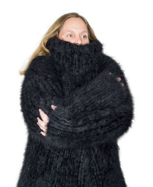 Model beyaz bir arkaplana karşı Angora süveteri giyiyor.