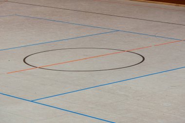 Hentbol salonu zemininde çeşitli hatları olan bir spor salonu.
