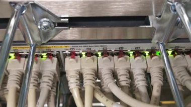 Bir veri merkezinde ağ kablosu RJ45 yama kablosu ve fiber optik kabloya bağlı ağ anahtarı