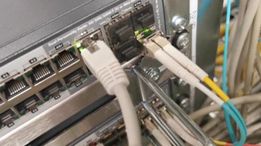 Bir veri merkezinde ağ kablosu RJ45 yama kablosu ve fiber optik kabloya bağlı ağ anahtarı