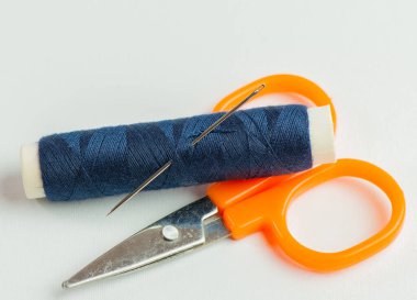 Bir terzide beyaz bir arka plana karşı çeşitli renklerde iplik ruloları dikmek