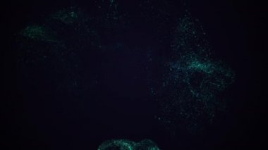 Mavi tozun dönen hareketi siyah arkaplanda sıçrıyor.