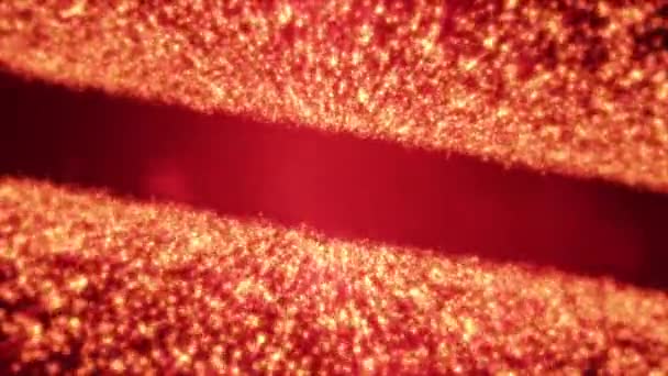 Partículas doradas que brillan formando una fila en medio del fondo negro . — Vídeos de Stock