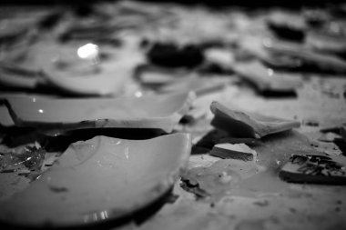 Tabak kırıkları masanın üzerinde. Masaya dağılmış kırık kil ve porselen parçaları. Beyaz arka planda farklı tabakların parçaları. Masada kırık tabak fincanları ve Chaniki var. siyah ve beyaz fotoğraf arkaplan dokusu