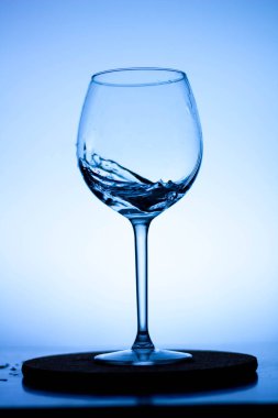Cam şarap kadehinde bir damla sıvı. Cam bir şarap kadehinin içine su dökülüyor. Şarap kadehinde bir bukle su. Bardakta içki. Bardakta su sıçradı.