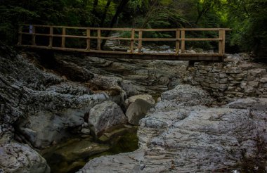 Soçi dağlarındaki kuru bir dağ nehrinin üzerindeki tahta köprü.