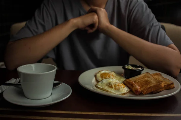 stock image girl in gray t shirt eats scrambled eggs with toast sausage and cheese