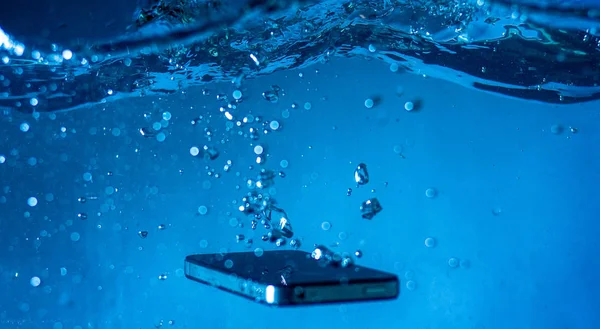 Siyah beyaz telefon suya düştü. Telefonun suda. Mavi su. Telefon su kabarcıklarında. Telefon suya batıyor.