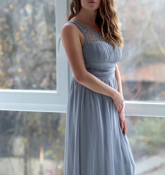 Mujer joven en vestido situado cerca de la ventana — Foto de Stock