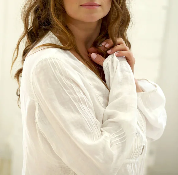 Jeune belle fille dans une chemise se dresse contre un mur blanc — Photo