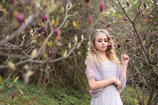 Junges schönes Mädchen in einem helllila Kleid im Garten, wo — Stockfoto