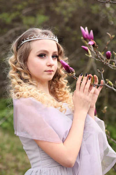 Giovane bella ragazza in un abito lilla chiaro in giardino dove — Foto Stock