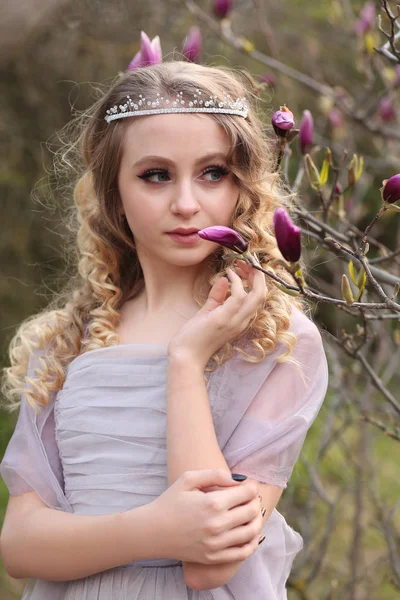 Jeune belle fille dans une robe lilas clair dans le jardin où — Photo