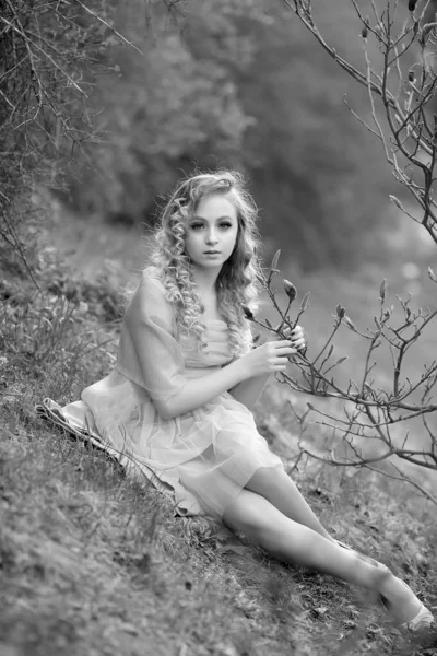 Junges schönes Mädchen in einem helllila Kleid im Garten, wo — Stockfoto