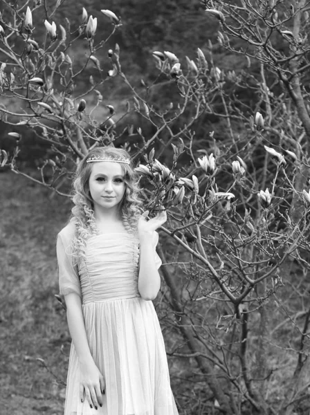 Fiatal gyönyörű lány egy könnyű orgona ruha a kertben, ahol — Stock Fotó