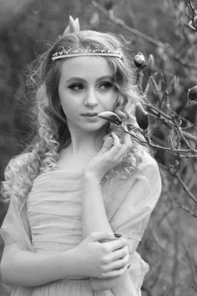 Young beautiful girl in a light lilac dress in the garden where — Stock Photo, Image