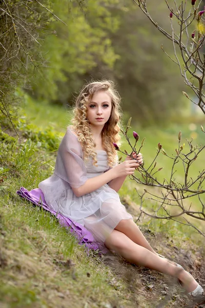 Junges schönes Mädchen in einem helllila Kleid im Garten, wo — Stockfoto