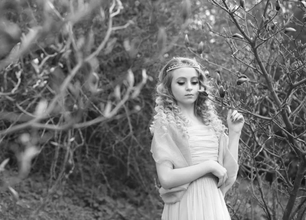 Νεαρή όμορφη κοπέλα σε ένα ελαφρύ λιλά φόρεμα στον κήπο, όπου — Φωτογραφία Αρχείου