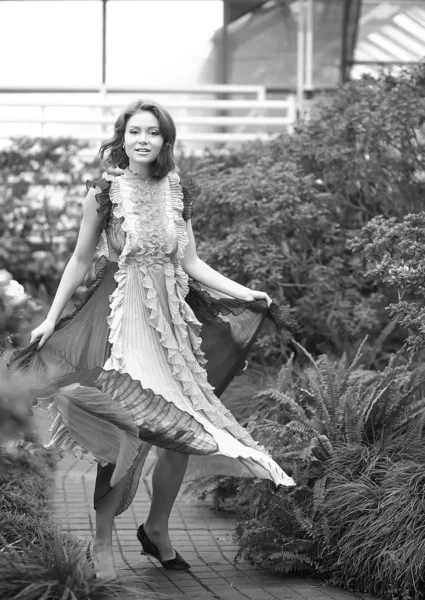 Hermosa chica pelirroja en arreglista donde azalea florece en un vestido volador colorido —  Fotos de Stock