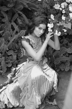 Renkli bir elbiseyle açelyanın açtığı aranjördeki güzel kızıl saçlı kız.