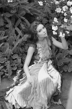 Renkli bir elbiseyle açelyanın açtığı aranjördeki güzel kızıl saçlı kız.