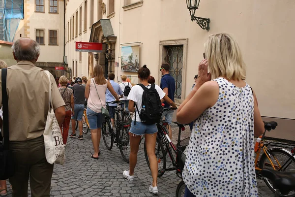 Turisté s jízdními koly a batohy procházka přes náměstí — Stock fotografie