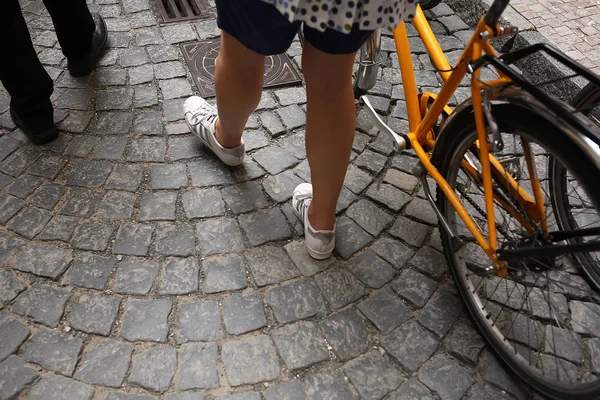 Tourists with bicycles and backpacks walk across the square — ストック写真