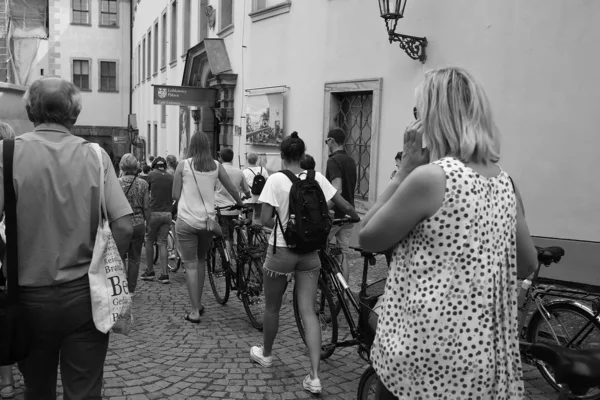 Turisté s jízdními koly a batohy procházka přes náměstí — Stock fotografie