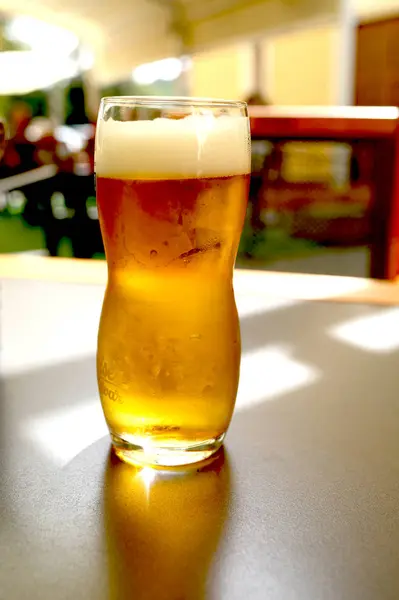 Taza de cerveza en una mesa de madera se encuentra en un pub — Foto de Stock