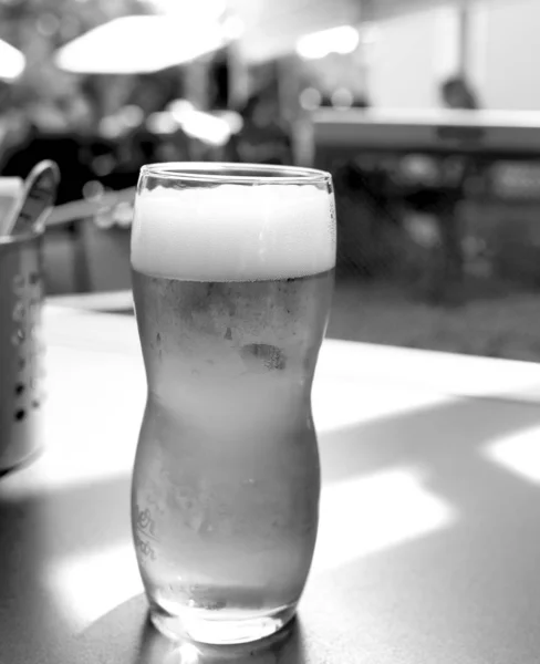Bira bardağı bir barda, ahşap bir masada duruyor. — Stok fotoğraf