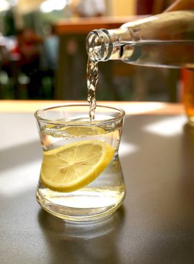 Maden suyu bir kafedeki masanın üstündeki bardağa dökülüyor.