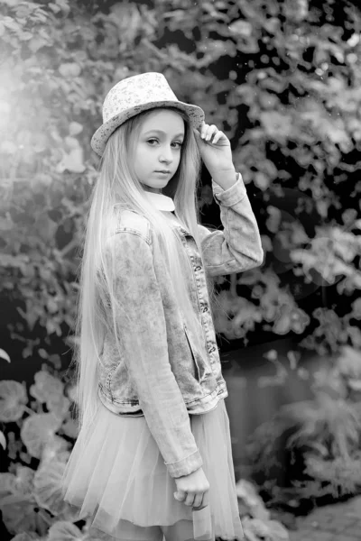 Menina com cabelos brancos longos em um chapéu e uma jaqueta de ganga anda — Fotografia de Stock