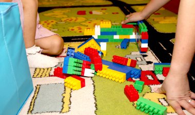 Kız parlak ve renkli bir çocuk tasarımcısı topluyor. 