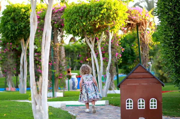 遊び場の木製の茶色の小さな家の近くで遊んでいる女の子 — ストック写真