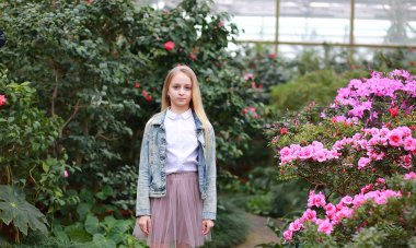 Uzun beyaz saçlı, şapkalı ve kot ceketli genç bir kız.