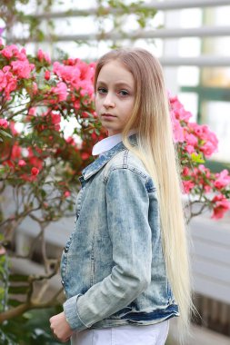 Uzun beyaz saçlı, şapkalı ve kot ceketli genç bir kız.