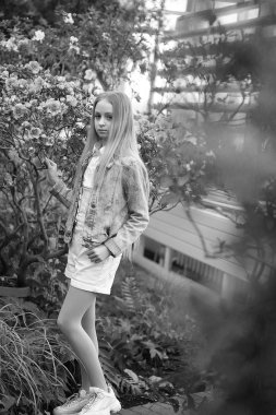 Uzun beyaz saçlı, şapkalı ve kot ceketli genç bir kız.