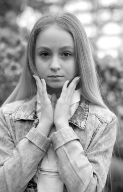 Uzun beyaz saçlı, şapkalı ve kot ceketli genç bir kız.