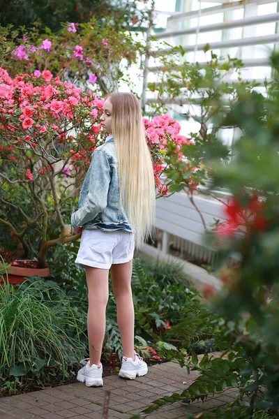 Jeune fille avec de longs cheveux blancs dans un chapeau et une promenade de veste en denim — Photo