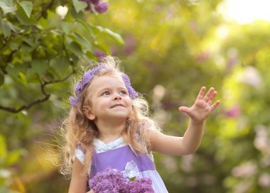 Küçük kız bahar botanik bahçesinde yürüyor. 