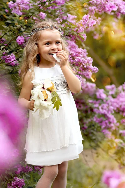 Kleines Mädchen im weißen Kleid spaziert durch den Botanischen Garten des Frühlings — Stockfoto