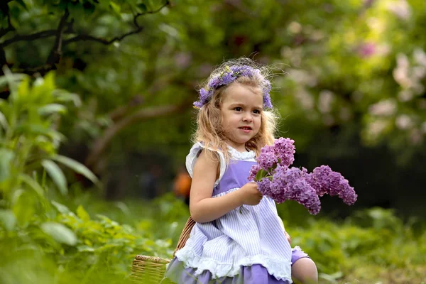 Little girl in a white dress walks in the spring botanical garden — Stock Photo, Image