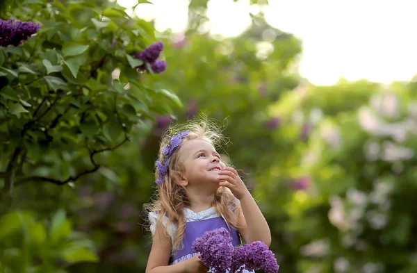 Kleines Mädchen im weißen Kleid spaziert durch den Botanischen Garten des Frühlings — Stockfoto