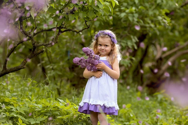 Kleines Mädchen im weißen Kleid spaziert durch den Botanischen Garten des Frühlings — Stockfoto