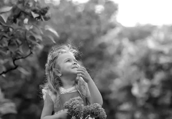 Little girl in a white dress walks in the spring botanical garden — Stock Photo, Image