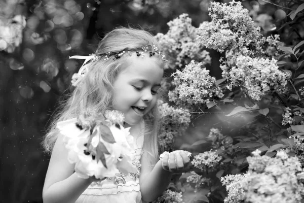 Little girl in a white dress walks in the spring botanical garde — 스톡 사진