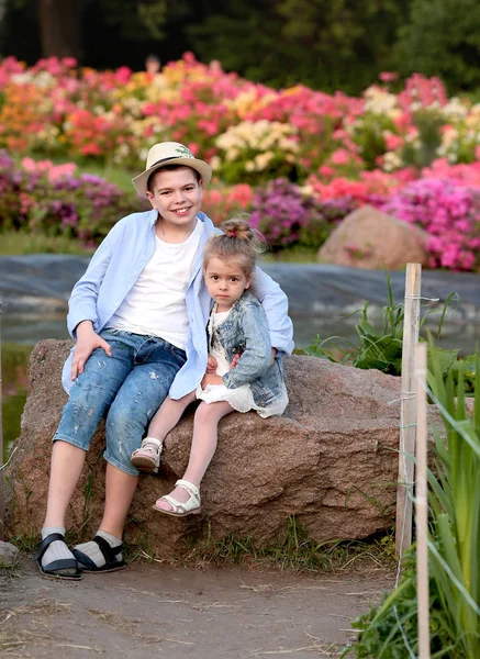 Frère et soeur marcher dans le jardin botanique au printemps — Photo