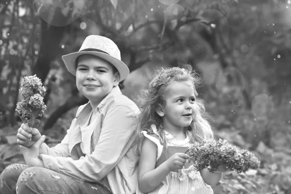Irmão e irmã caminham no jardim botânico na primavera — Fotografia de Stock